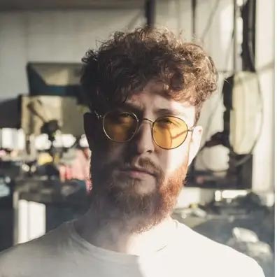 Barber 1 young man with beard smiling and wearing a  brown shirt